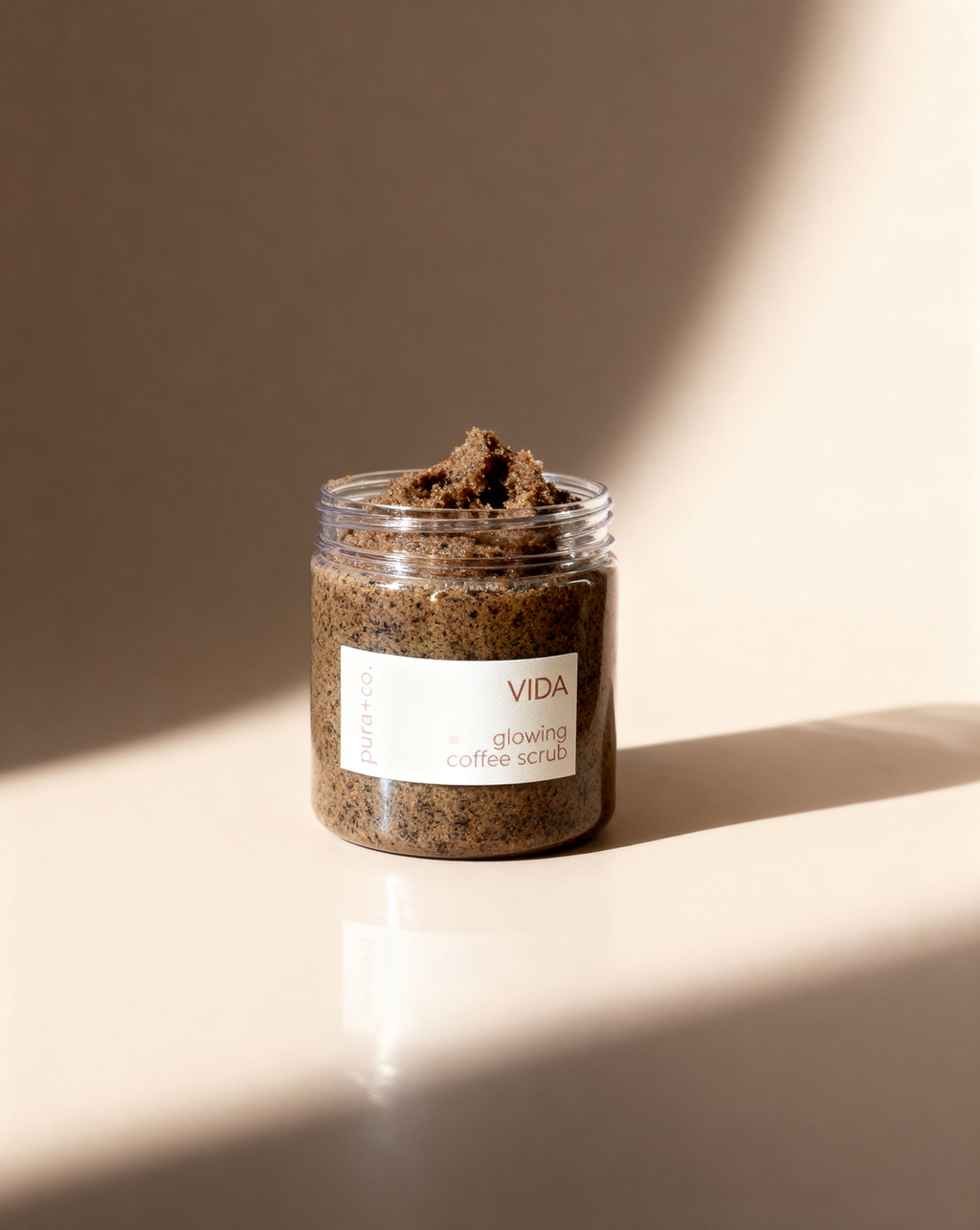 Pura+Co | The Vida Coffee Scrub jar sits on a solid surface | Exfoliante Natural |  Amber Mandarin Scent | Handmade Skin Care | Puerto Rico