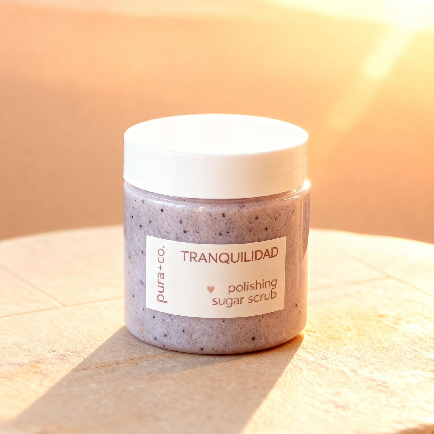 Pura+Co | Tranquilidad Sugar Scrub jar sits on a tiled surface | Exfoliante Natural |  Lavender Vanilla Scent | Handmade Skin Care | Puerto Rico